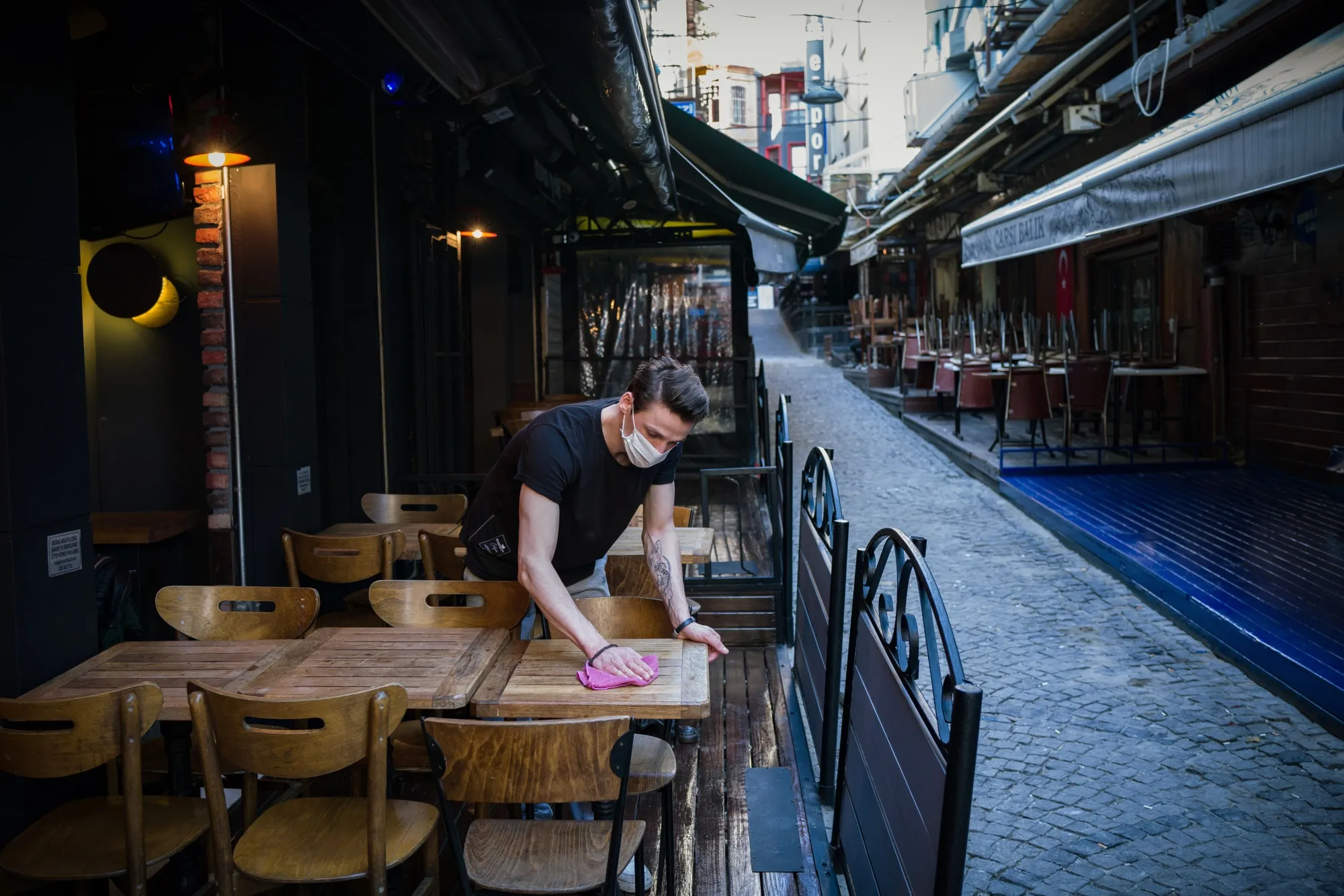 An employee cleans the terrace tables at a cafe in Istanbul.