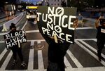 Protestors stand at an intersection near the Transit Center as they march uptown in Charlotte, N.C., on Wednesday, Sept. 21, 2016.
