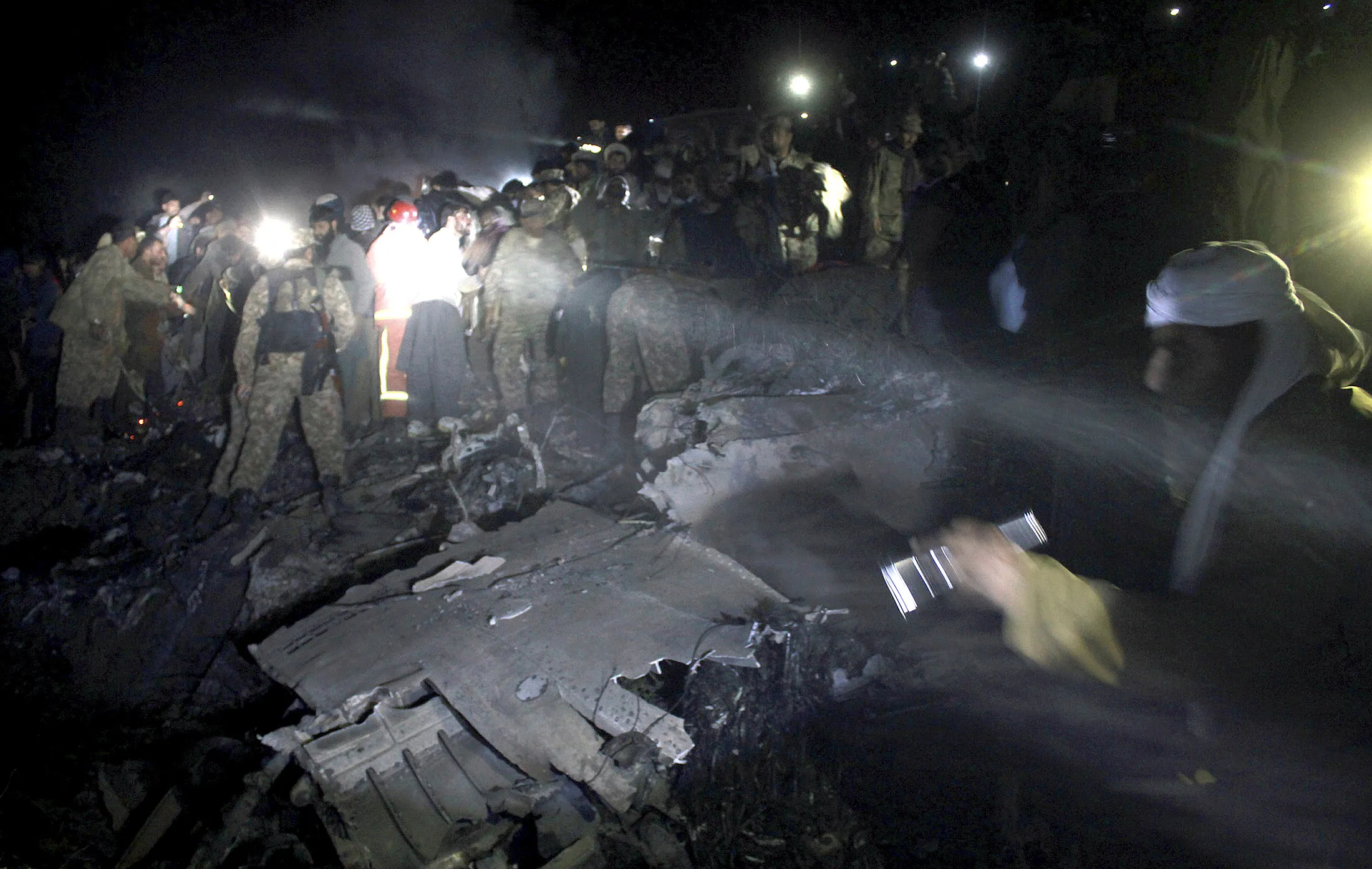 Pakistan army troops and rescue workers at the site of a plane crash, in a village near the town of Havelian, Pakistan, on Dec. 7, 2016.

