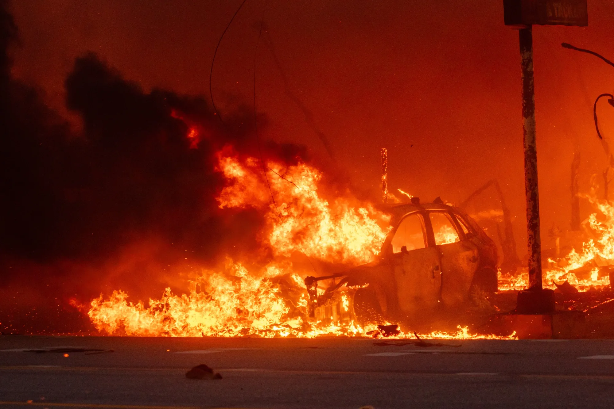 A car burns in the Pacific Palisades neighborhood of Los Angeles on Tuesday.