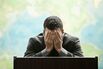 Frustrated Hispanic businessman standing at podium