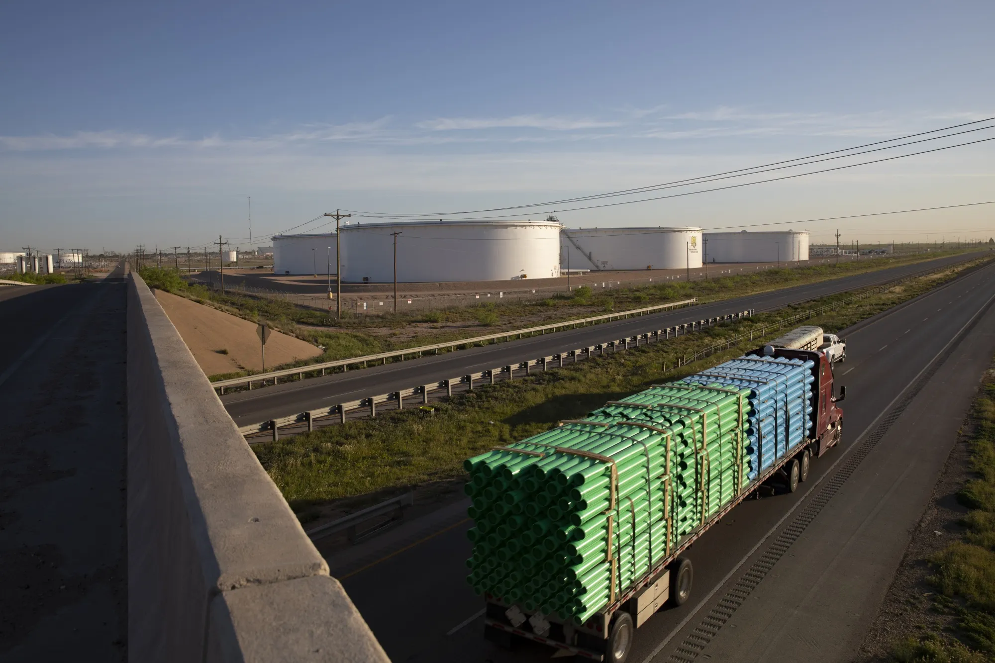 A truck passes crude oil storage tanks outside Midland, Texas.