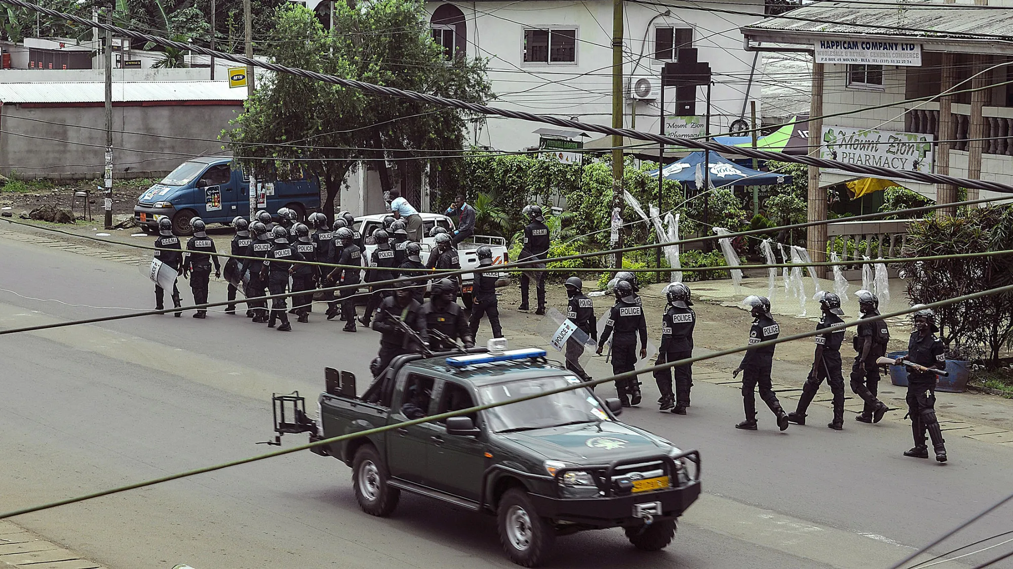 Cameroon police officials with riot equipment patrol along a street in the administrative quarter of Buea some 60kms west of Douala on October 1, 2017. A young man from Cameroon's English-speaking region was shot dead by security forces in the city of Kumba on the eve of an expected symbolic declaration of independence by anglophone separatists, medical and security forces told AFP. / AFP PHOTO / STRINGER (Photo credit should read STRINGER/AFP/Getty Images)
