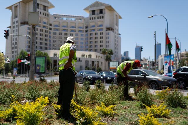 Workers plant flowers and plants on the roadside in the Fifth Circle area of Amman.