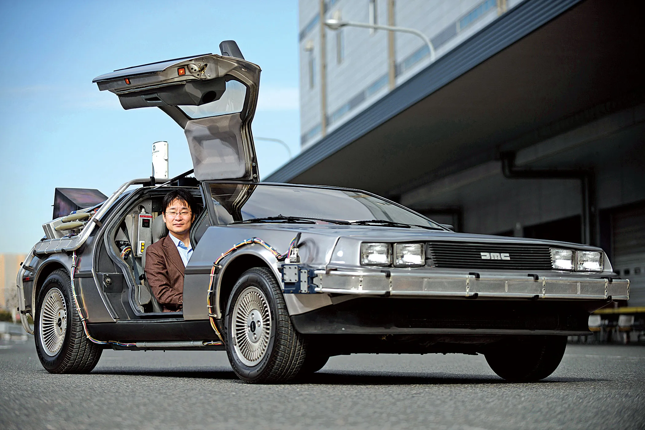 CEO and co-founder Masaki Takao sits in a replica of the DeLorean time machine featured in Back to the Future.
