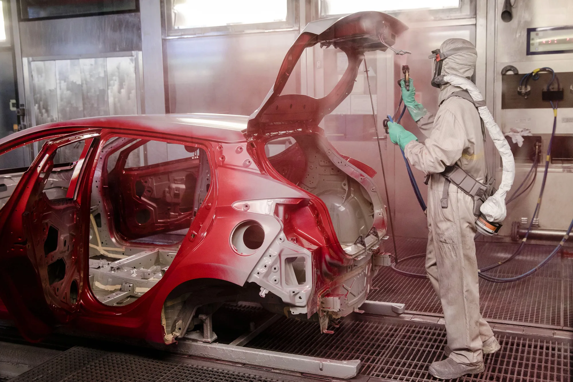 An employee hand spray paints the body shell of a Nissan Micra automobile at the Renault SA factory in Flins, France, on Thursday, Feb. 23, 2017. Carlos Ghosn, one of the auto industry's most celebrated turnaround artists, is relinquishing his CEO role at Nissan Motor Co. and turning over day-to-day control to Hiroto Saikawa as he focuses on strengthening the carmaker's alliance with Renault and Mitsubishi Motors Corp.
