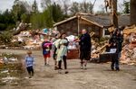 Resident Stephanie Kerwin, center, holds her baby Octavius in one arm and dog Pixie in the other as she and her family carry what they could salvage from her home in Nottingham Forest Mobile Home Park, Saturday, May 21, 2022, in Gaylord, Mich., following a tornado the day before. &quot;This morning is when it first hit me...I could have lost people that I really love. I am so grateful,&quot; Kerwin said. (Jake May/MLive.com/The Flint Journal via AP)