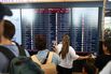 Travelers check flight departure information at Berlin Brandenburg Airport