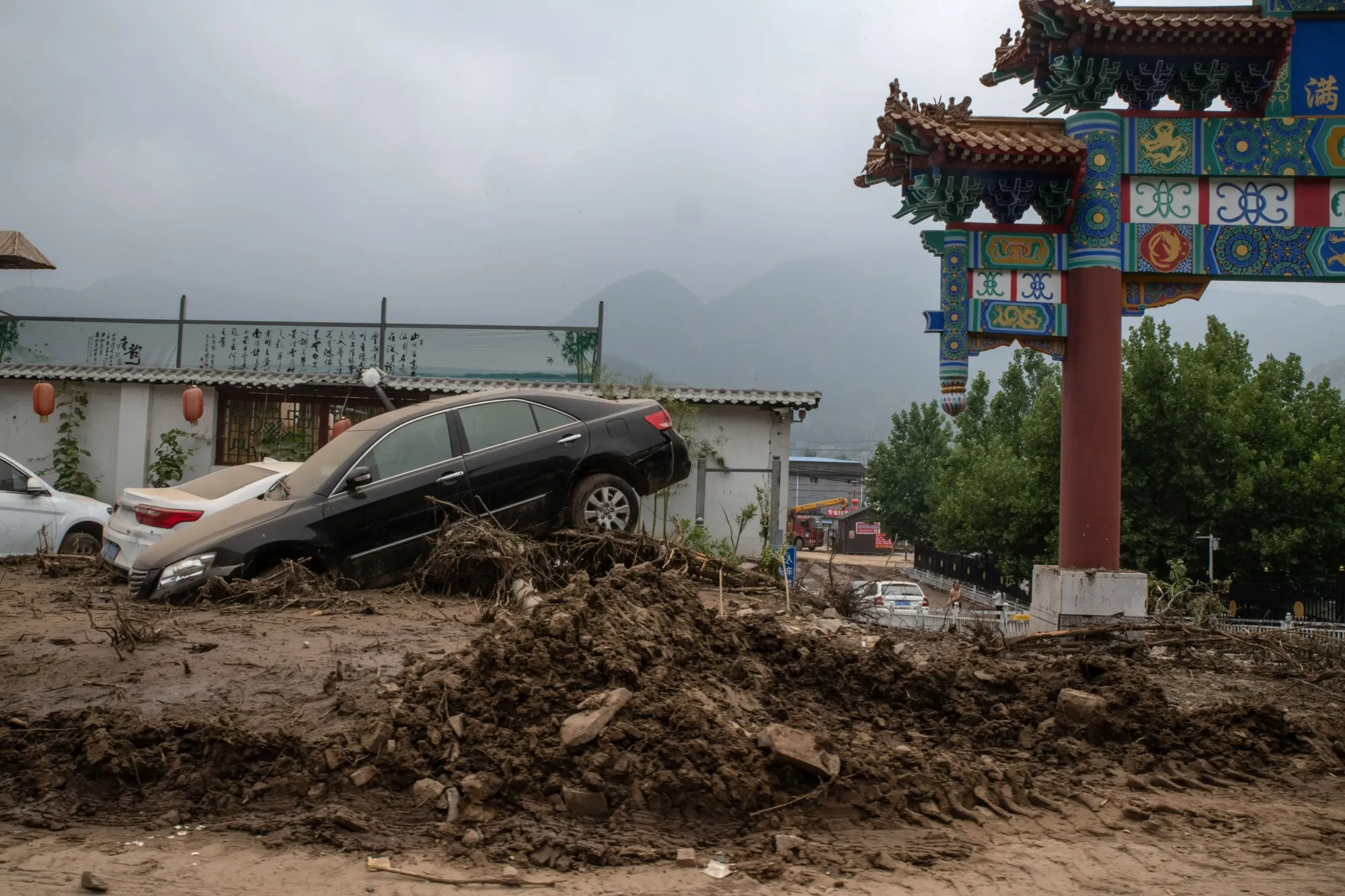 Vehicles stranded in mud following Typhoon Doksuri in the Mentougou district of Beijing, China, on Thursday, Aug. 3, 2023. The deluge of rain that triggered floods and killed at least 20 people in northern China this week was the heaviest to hit Beijing since record-keeping began in the 19th century.