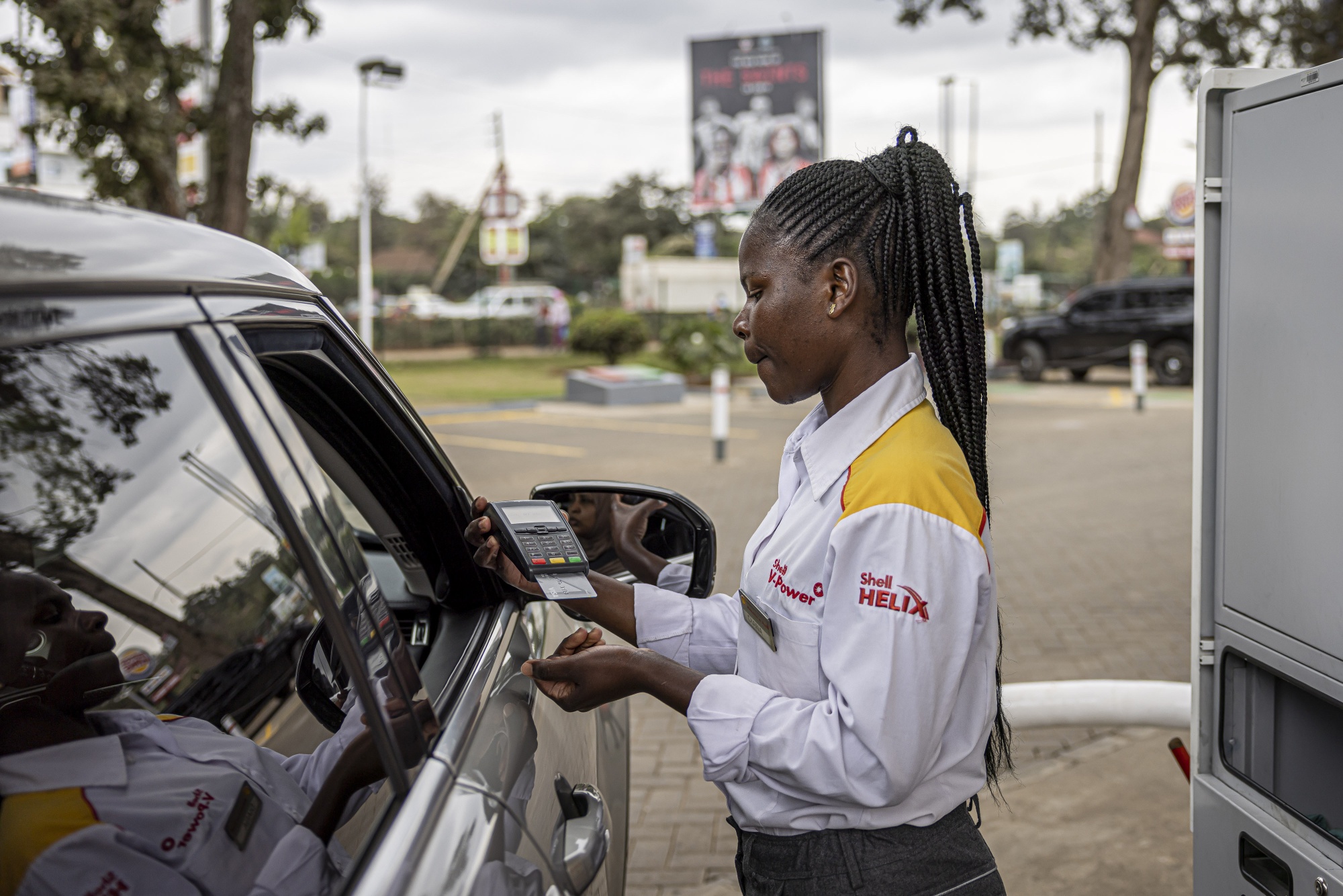 An attendant takes payment from a customer after refueling at a Shell Plc gas station in Nairobi, Kenya, on Tuesday, July 25, 2023. The leader of Kenya’s main opposition coalition Raila Odinga said he’s ready to hold talks with the government even as he vowed to continue with demonstrations to demand tax cuts and an audit of last year’s elections that brought President William Ruto to power.