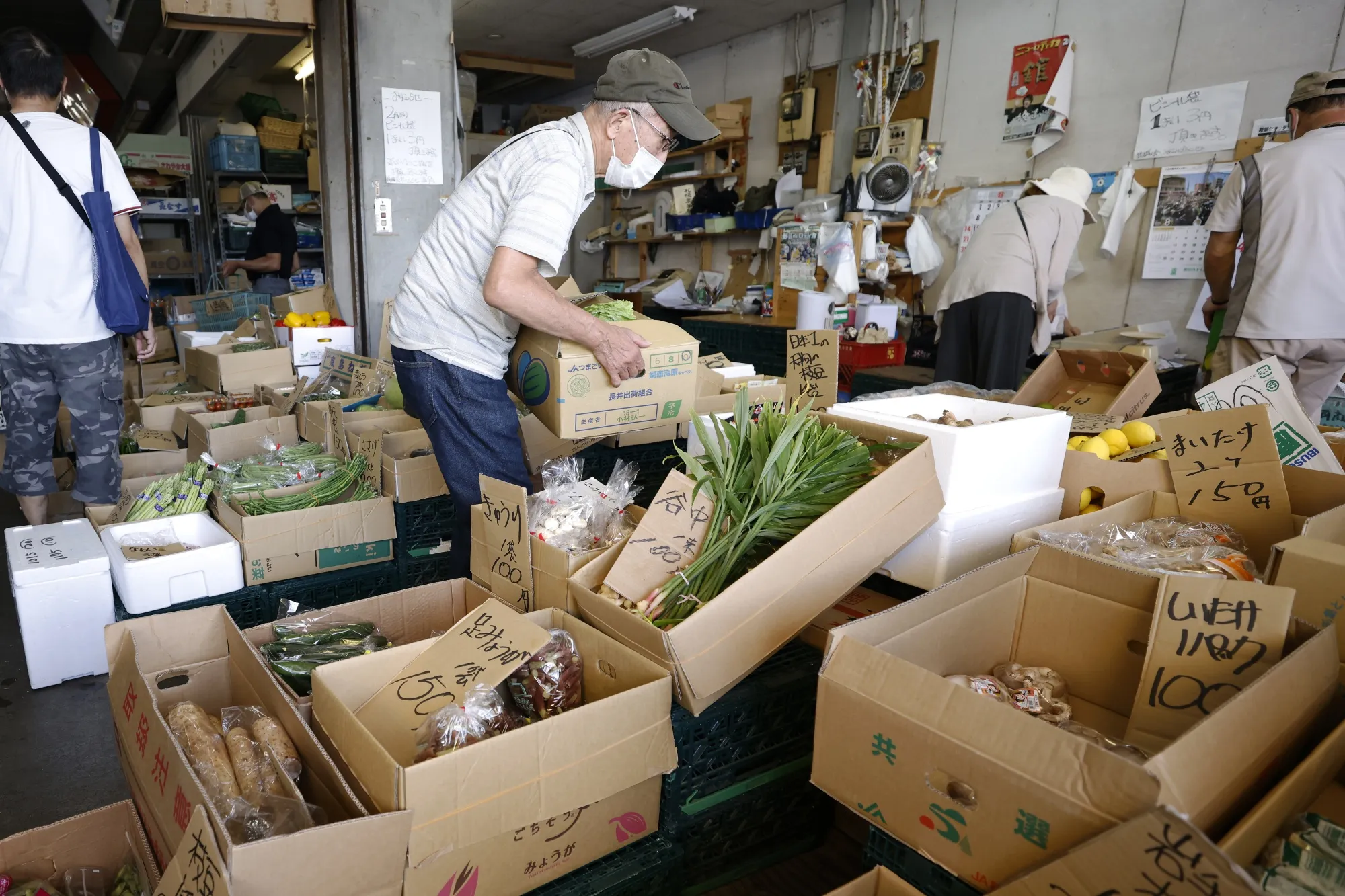 Customers shop at a fruit and vegetable stall inside the Hachioji Wholesale Center in Tokyo earlier in August.