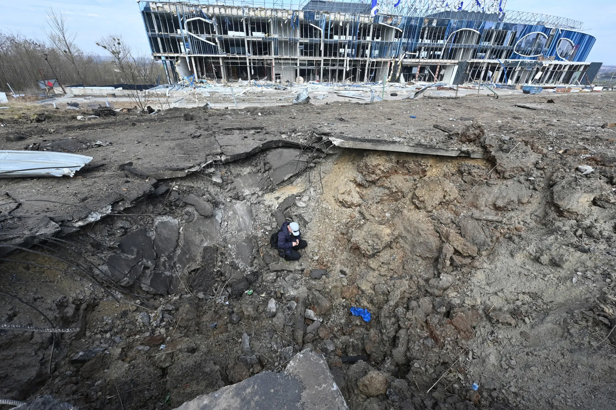 A Ukrainian worker sits in a crater after Russian missiles strike&nbsp;Kharkiv&nbsp;on April 6.