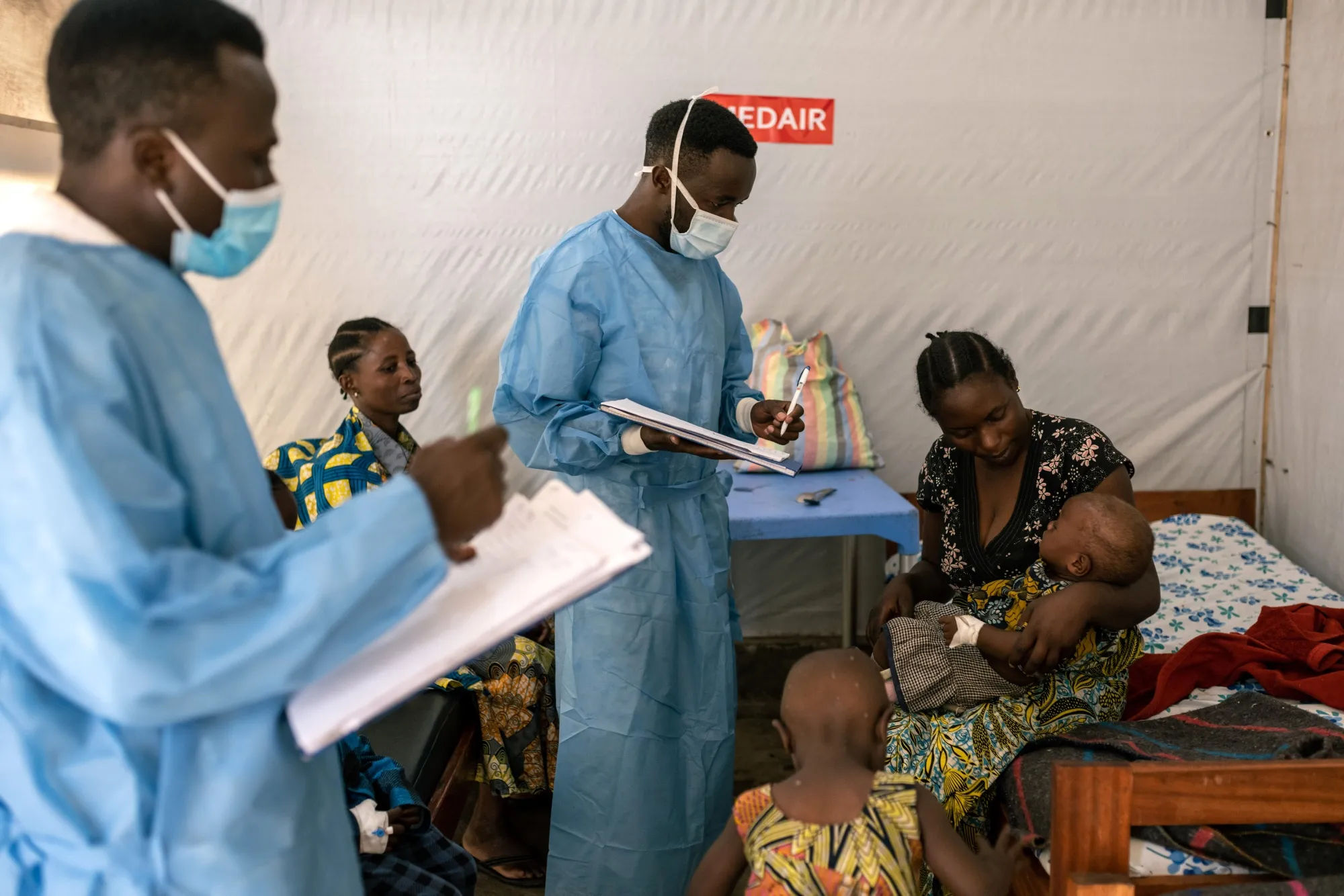 Health workers with children being treated for mpox in a treatment room at the Munigi treatment center in North Kivu, Democratic Republic of Congo, on Aug. 17.