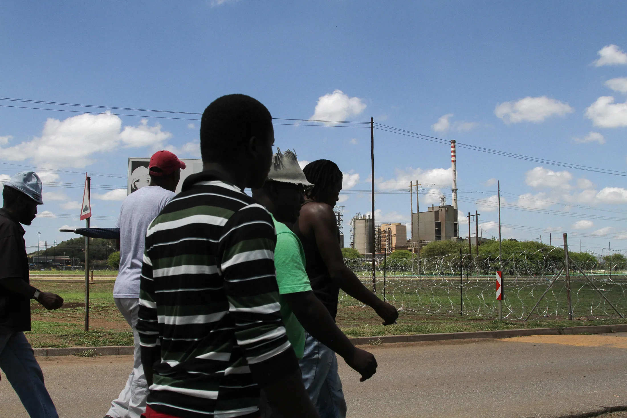 Striking members of the Association of Mineworkers and Construction Union (AMCU) leave after a union meeting outside Lonmin Plc's Wonderkop platinum processing plant in Marikana, South Africa, on Thursday, Feb. 13, 2014.
