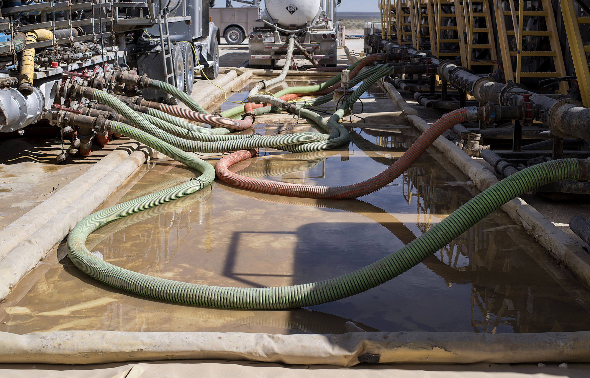 Hoses carry water to hydraulic fracking machinery at at a site near Mentone, Texas.