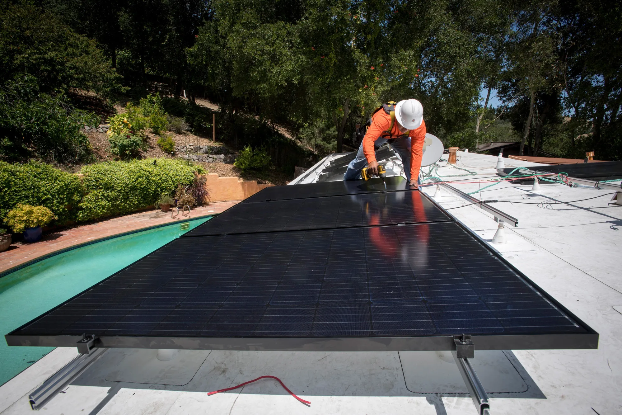 A contractor installs solar panels on the roof of a home in Lafayette, Calif.