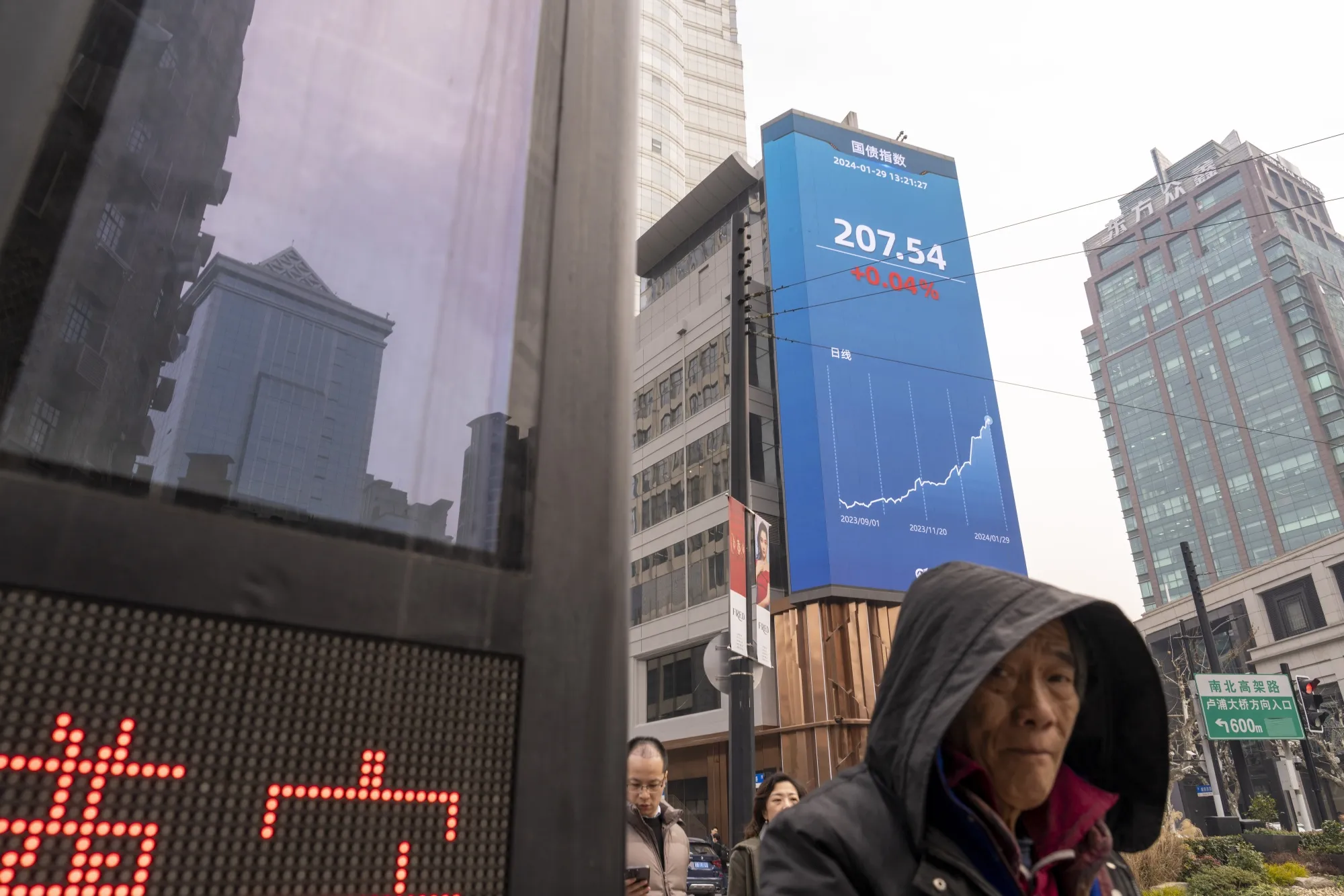A screen displays stock figures in Shanghai.