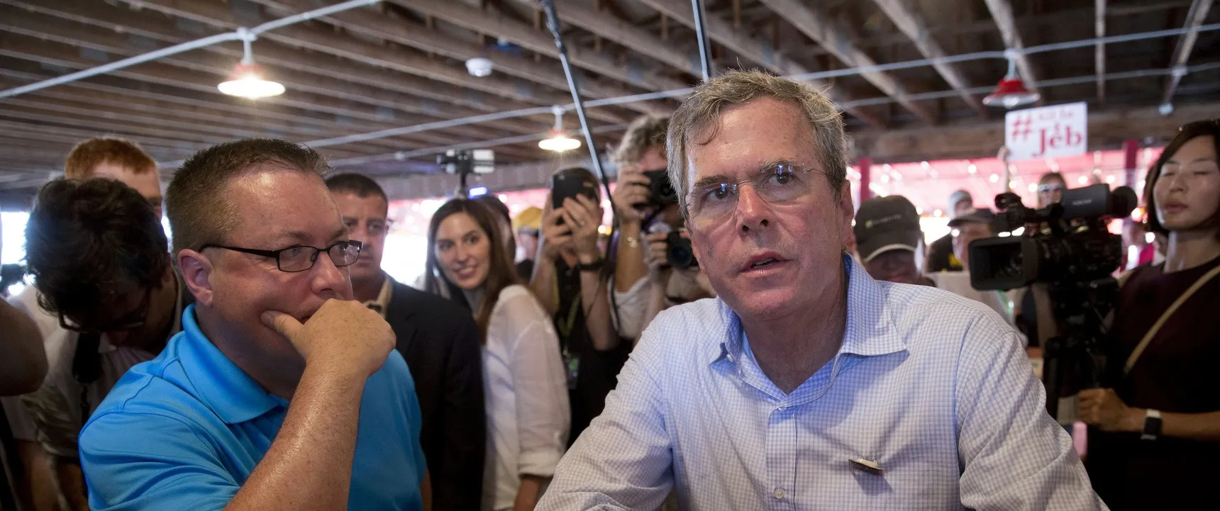 Jeb Bush, former governor of Florida and 2016 Republican presidential candidate, right, drinks a beer as he talks to Chris McLinden, Bush’s Dallas county chair, in a beer tent at the Iowa State Fair in Des Moines, Iowa, U.S., on Friday, Aug. 14, 2015. Sampling a fried Snickers bar and sidestepping a few hecklers, Jeb Bush made his way through the Iowa State Fair on Friday as he tried, and at times showed signs of struggling, to present himself as a fresh voice in the Republican presidential field.
