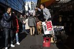 A vendor, right, calls out to shoppers at Ameyoko market in Tokyo, Japan, on Tuesday, Jan. 1, 2019.