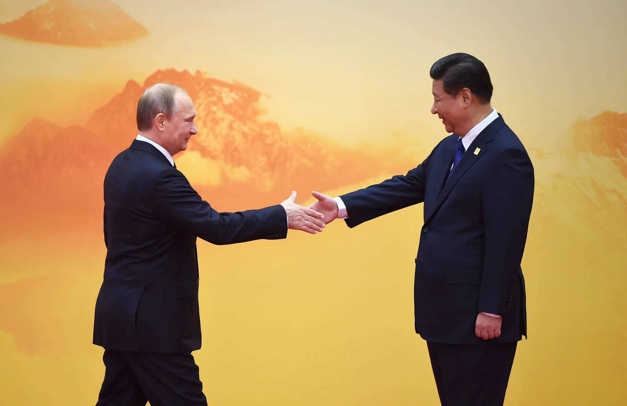 Russia's President Vladimir Putin shakes hands with China's President Xi Jinping.
