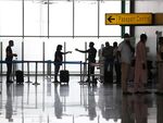 Passengers wait in line at the departure terminal of the Nnamdi Azikiwe International Airport, in Abuja, Nigeria.