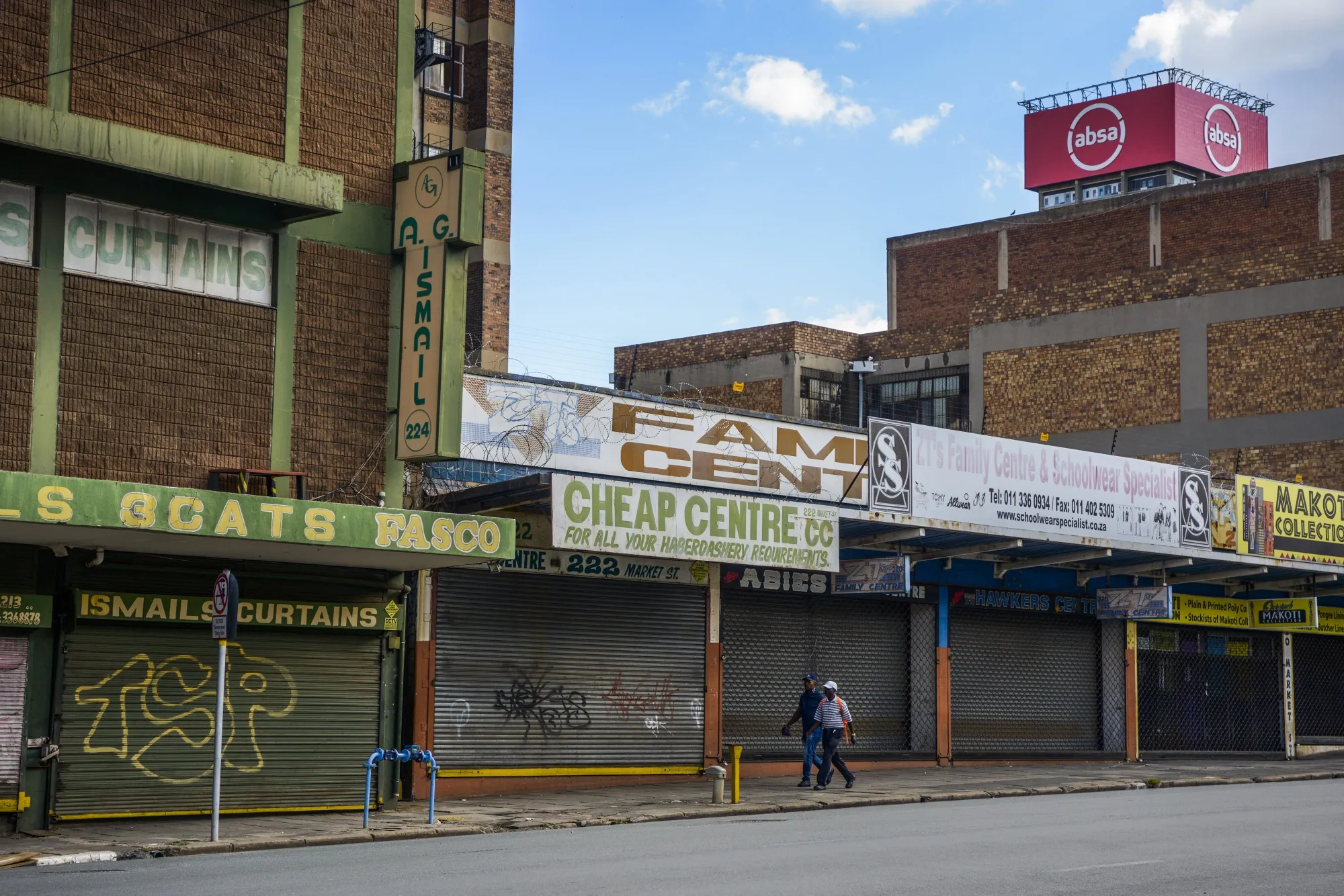 Pedestrians walk by shuttered stores in the the Central Business District of Johannesburg, South Africa on April 6.