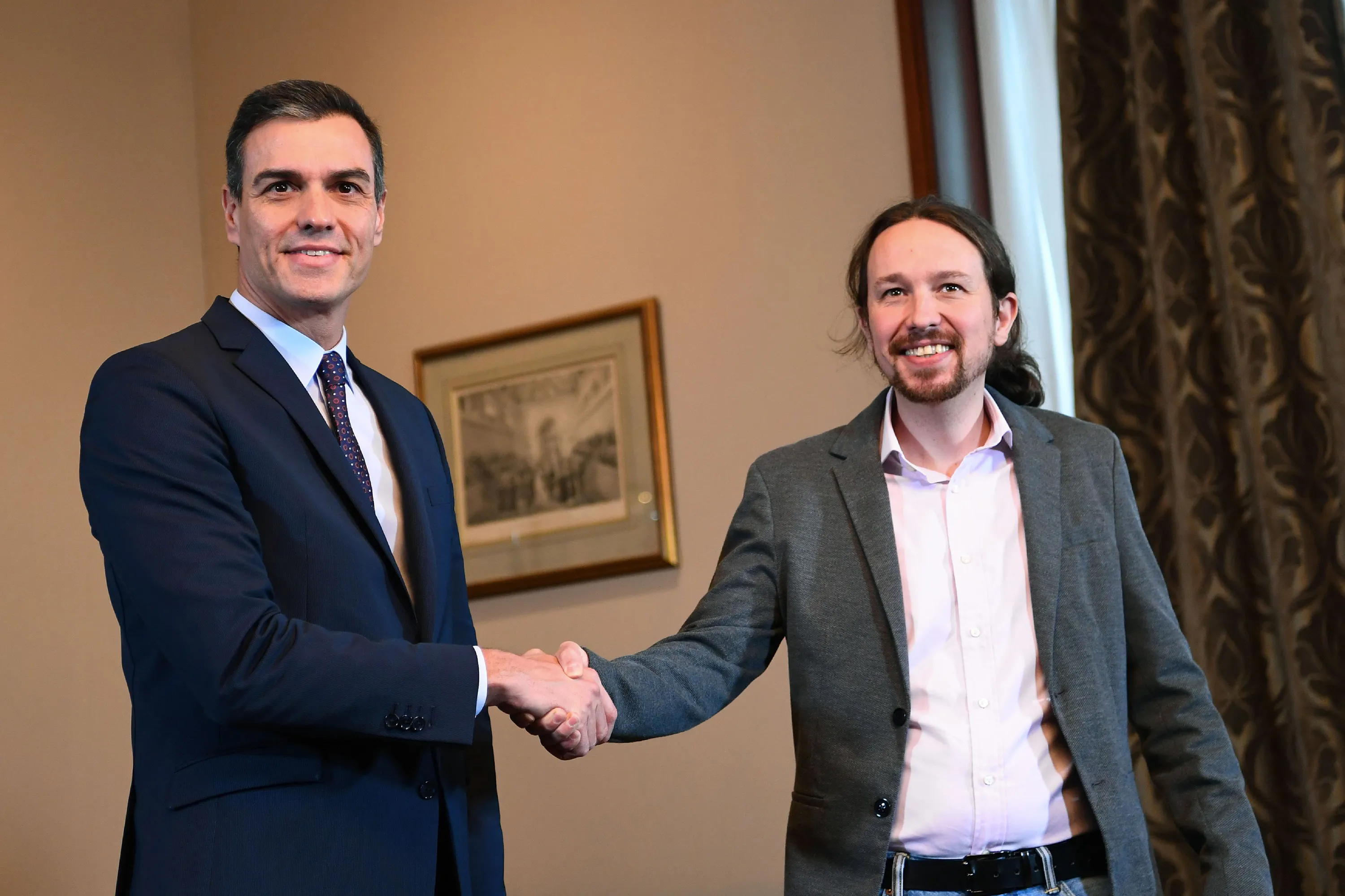 Pedro Sanchez, left, and Pablo Iglesias&nbsp;shake hands during a press conference in Madrid on Nov. 12.