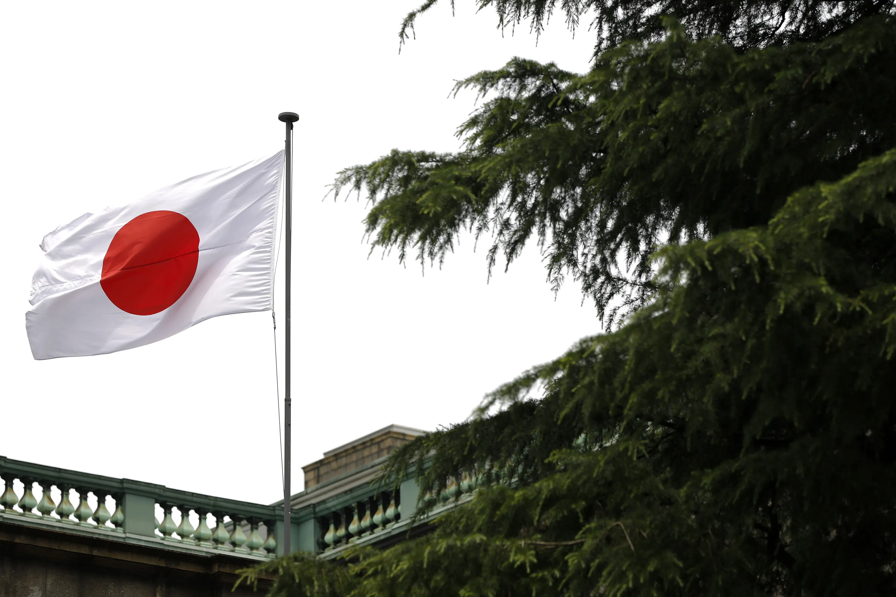 The Japanese national flag flies atop the Bank of Japan headquarters in Tokyo.