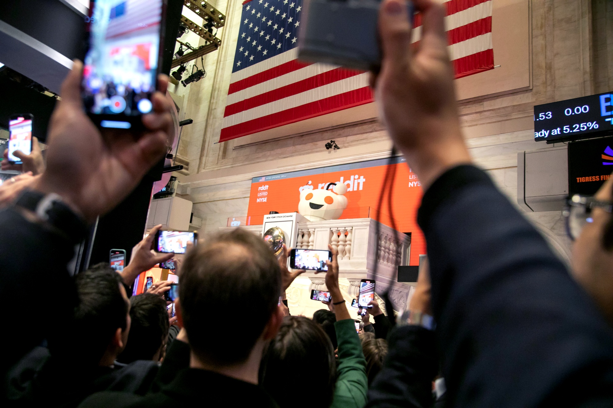 Snoo, mascot of Reddit Inc., rings the opening bell on the floor of the New York Stock Exchange.