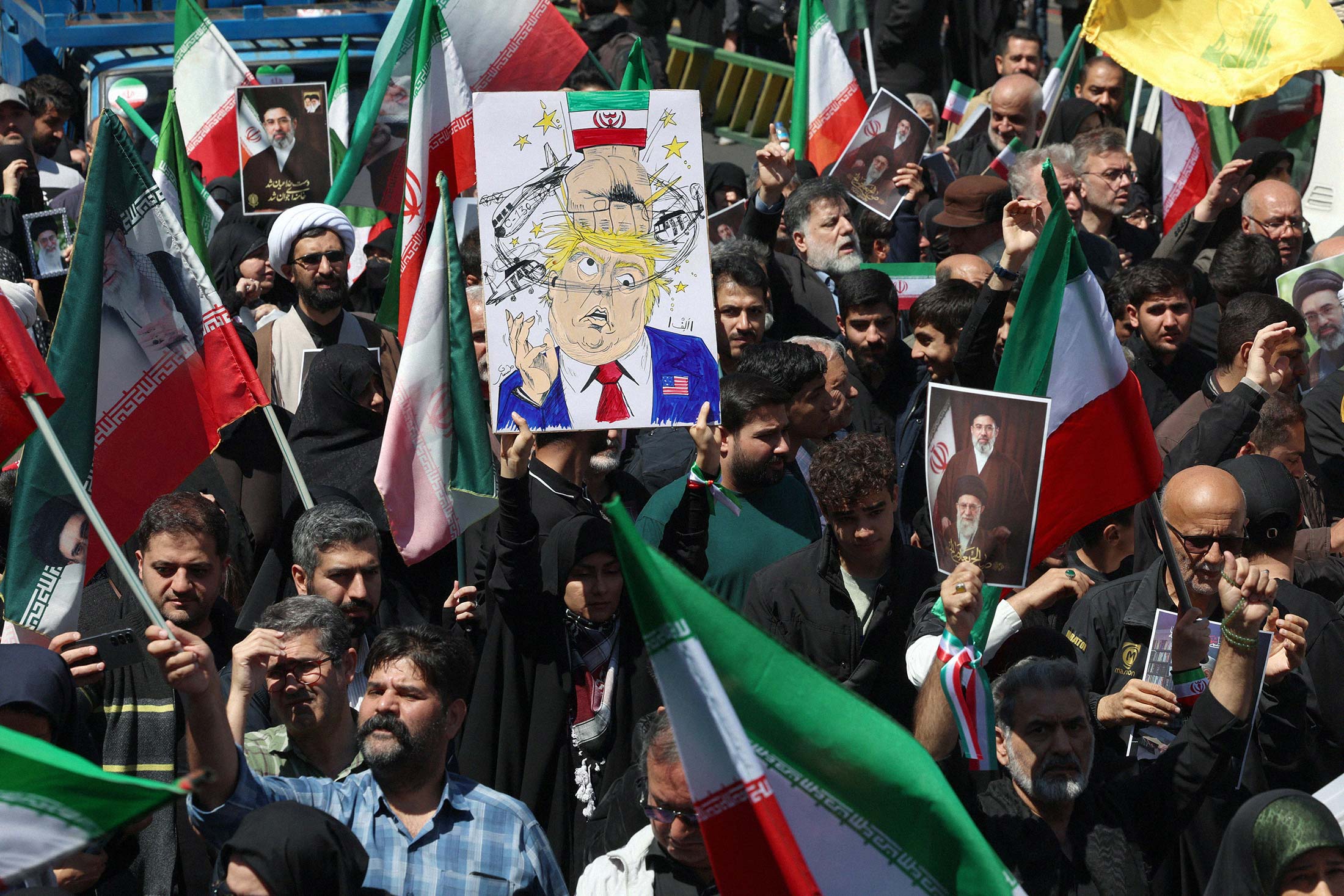 A woman holds a poster mocking US President Donald Trump while others hold portraits of Iran’s slain supreme leader Ayatollah Ali Khamenei and his son and successor Mojtaba Khamenei during a rally to commemorate his death in Tehran on April 9, 2026. Photo: AFP/Getty Images