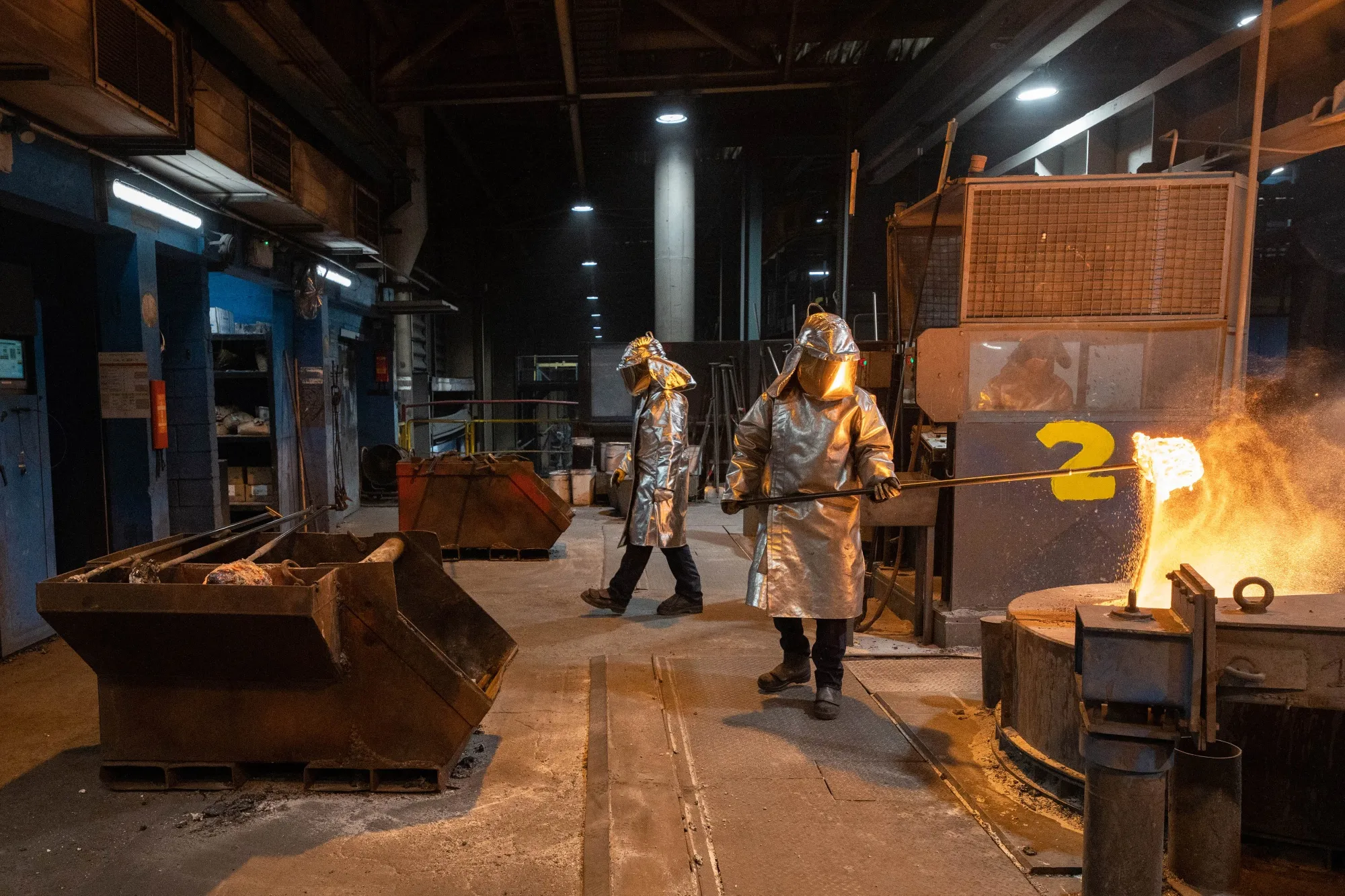 A worker removes a sample from a crucible of molten aluminum in a foundry in Dunkirk, France.