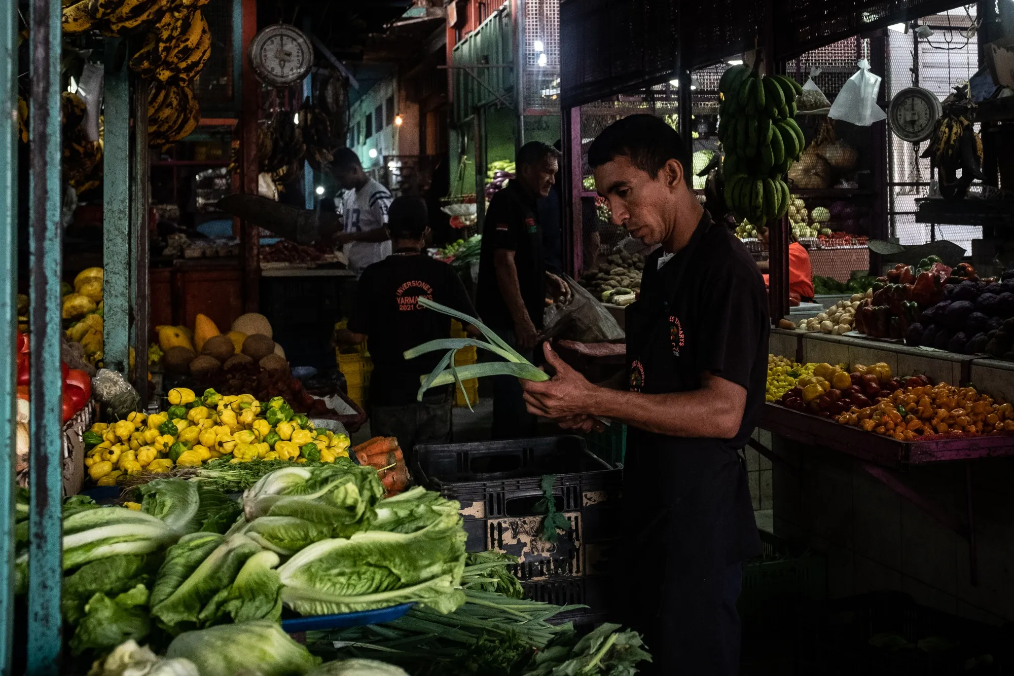 A worker organizes vegetables for sale in Barquisimeto, Venezuela.
