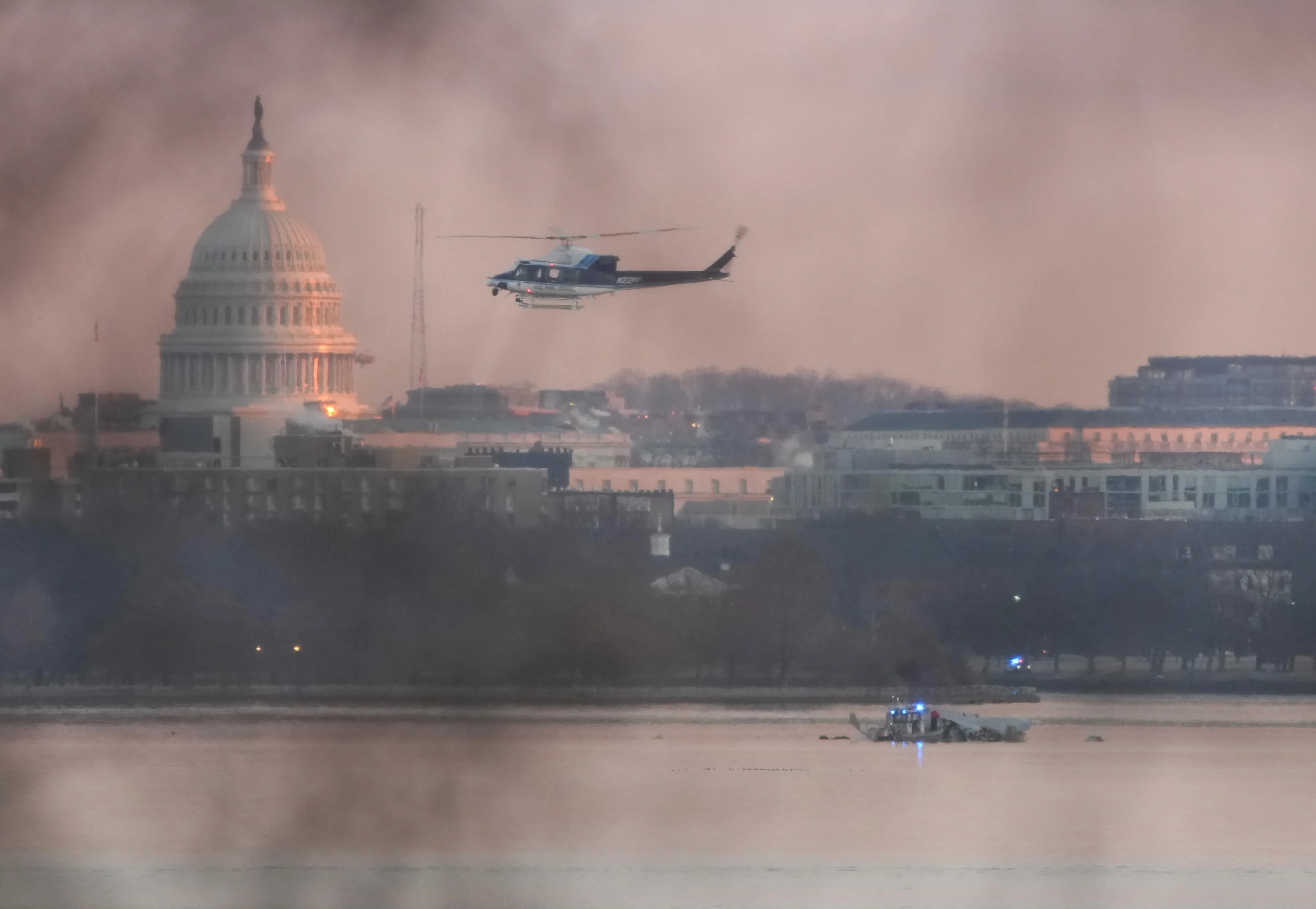 A helicopter flies near the crash site of an American Airlines plane on the Potomac River&nbsp;on Jan. 30, 2025.