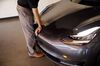 An employee closes the front hood of a Tesla Inc. Model 3 electric vehicle.