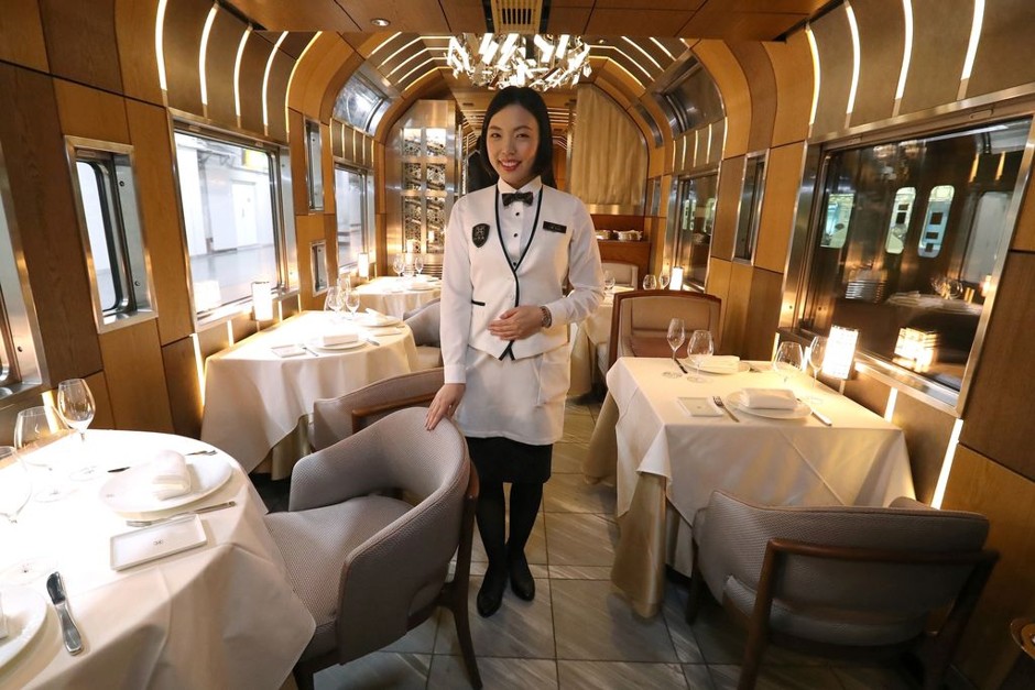 A crew member introduces the dining car of the Train Suite Shiki-Shima, operated by East Japan Railway.