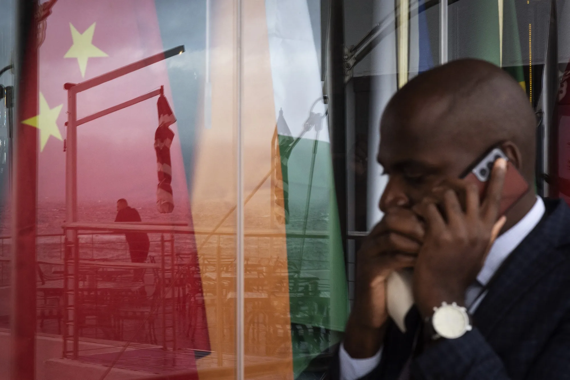 Flags of the BRICS group of nations reflected in a window.