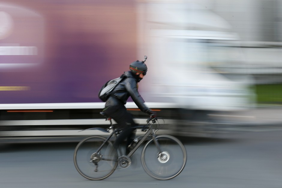 A cyclist pedals past a truck in London.