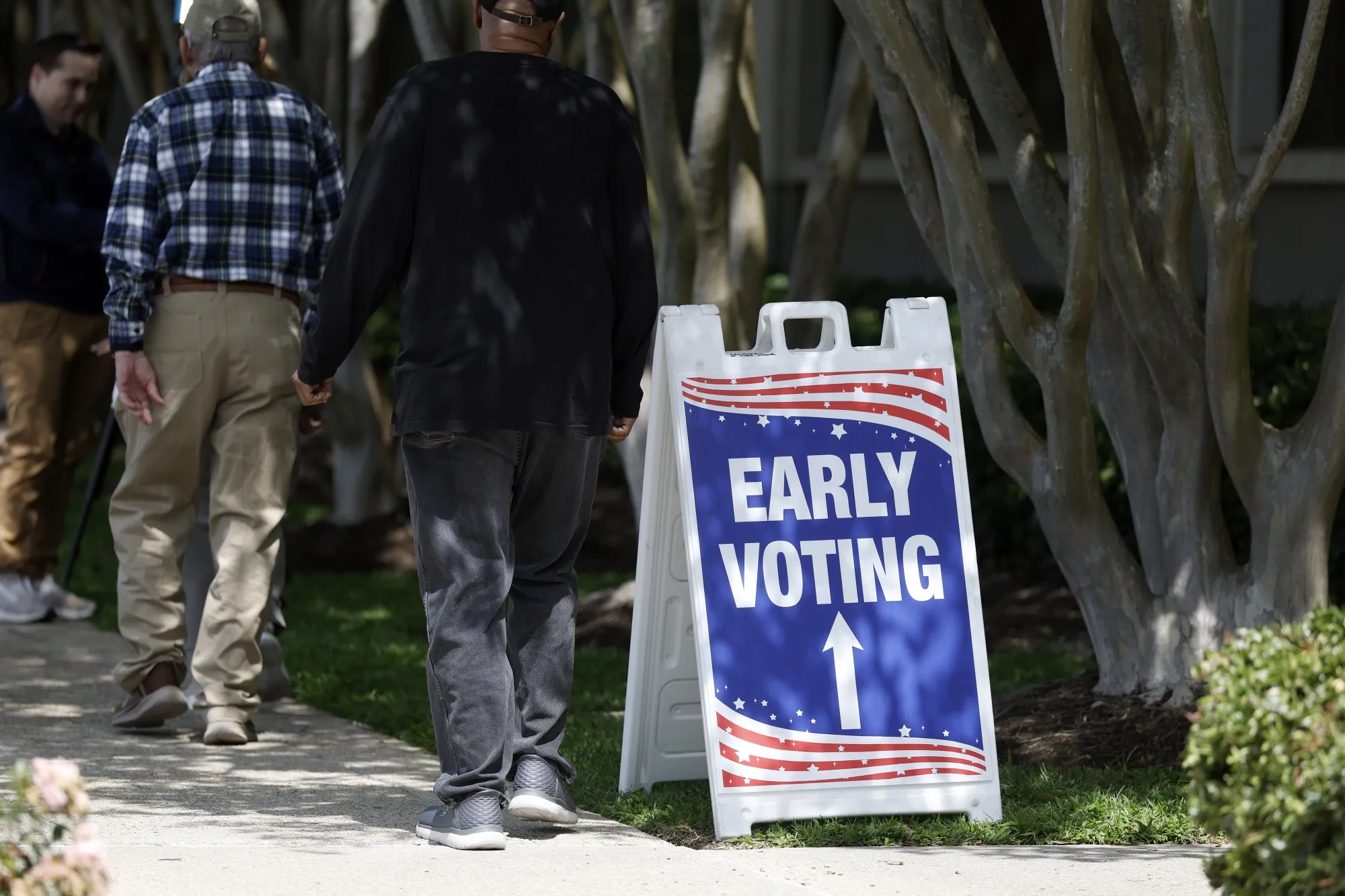 Voters walk by an early voting sign outside of the Louisiana State Archives in Baton Rouge, Louisiana on May 2.