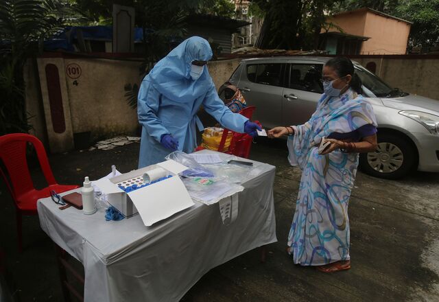 A health worker checks the Aadhaar card of a woman as he screens people for COVID-19 symptoms at a residential building in  Mumbai, India, Wednesday, July 22, 2020.