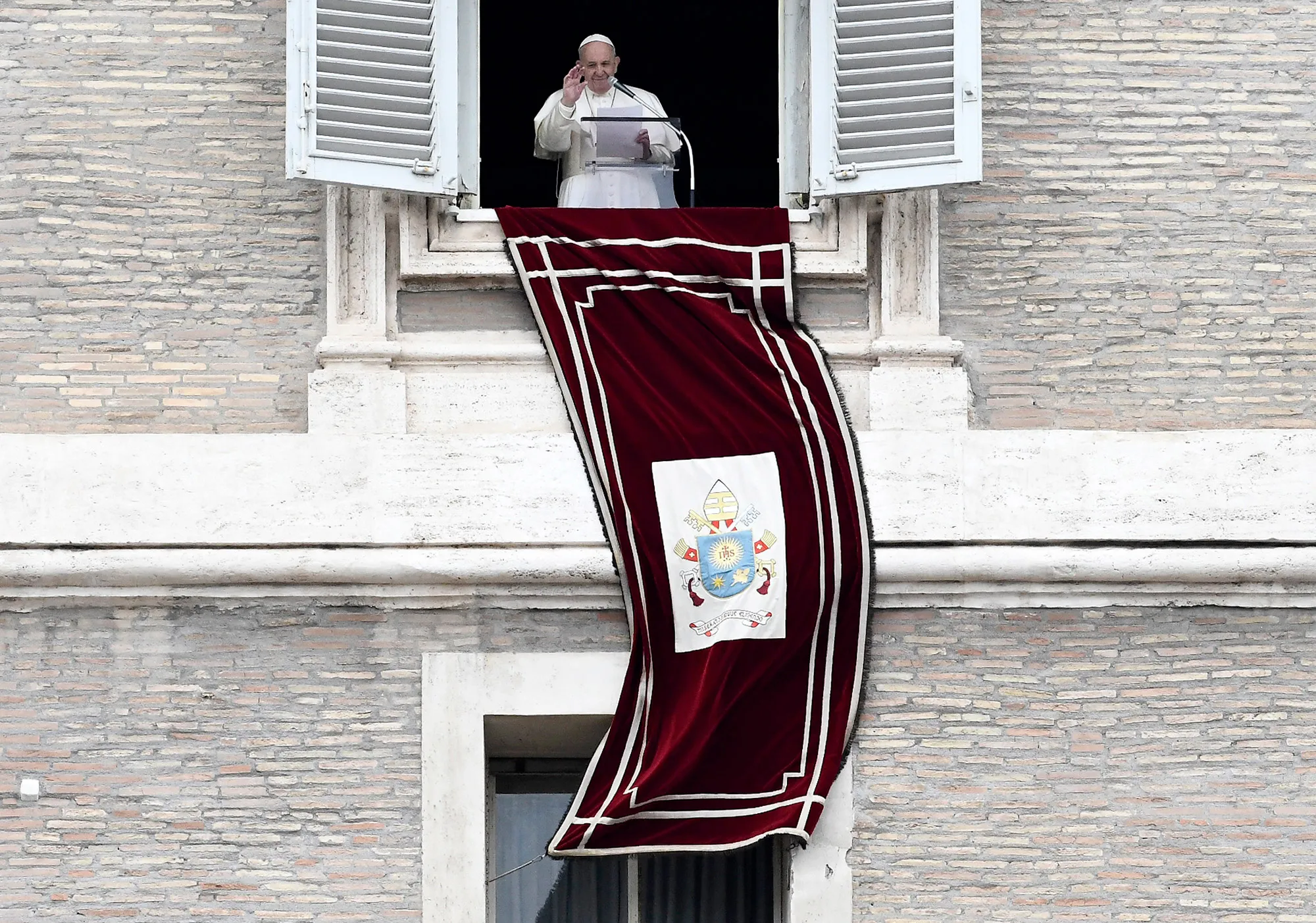 Pope Francis waves to the faithfuls as he delivers the Sunday Angelus prayer from his studio window at the Vatican on March 1.&nbsp;