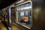A commuter wearing a protective masks sits inside a subway stopped at a station in New York on June 3.