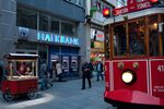 A tram and pedestrians pass a branch of Turkiye Halk Bankasi AS, or Halkbank, in Istanbul, Turkey.