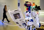 A robot holds a newspaper during a demonstration during the World Economic Forum annual meeting in Davos.