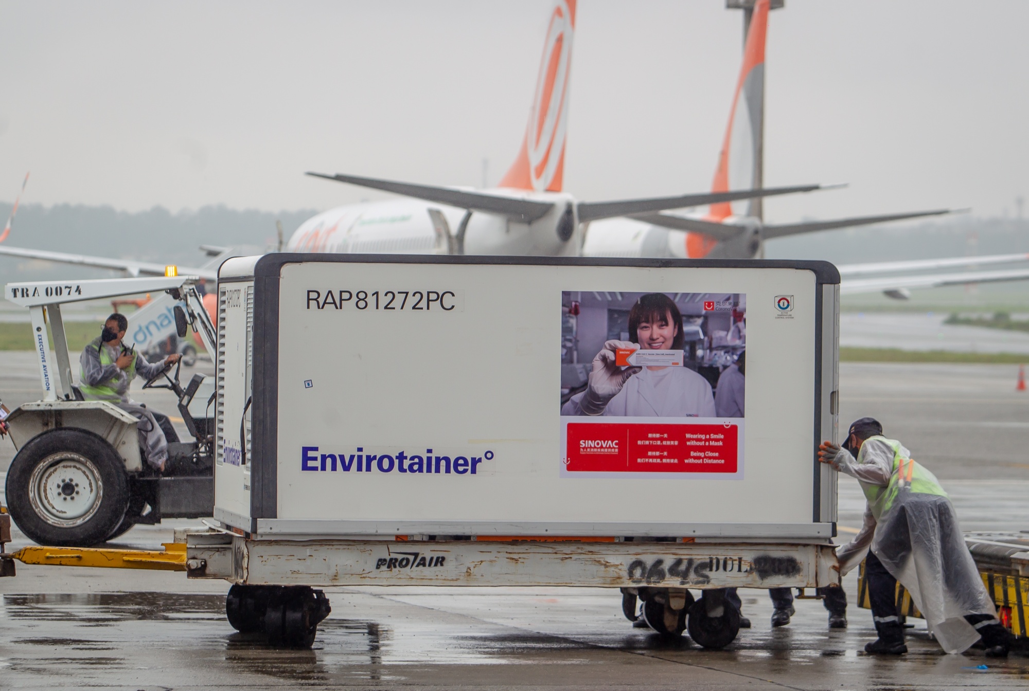 Workers unload a refrigerated container with Sinovac Biotech Ltd.'s coronavirus vaccines at Guarulhos International Airport in Sao Paulo on November 19.