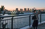 A person takes a photo of floating Olympic rings installed near Odaiba island, Tokyo on March 24.