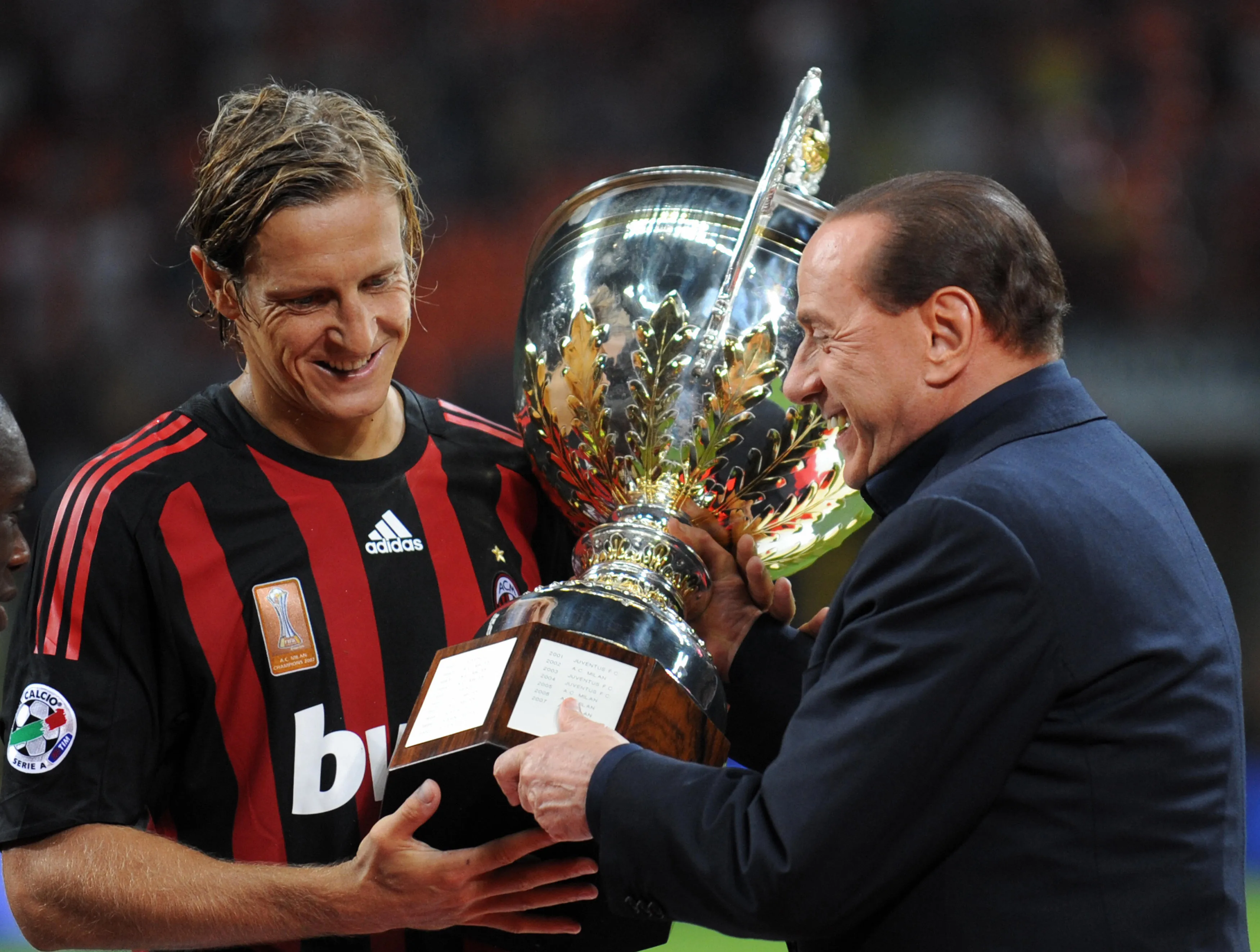 AC MIlan's captain Massimo Ambrosini receives the cup from Italian Prime Minister Silvio Berlusconi.
