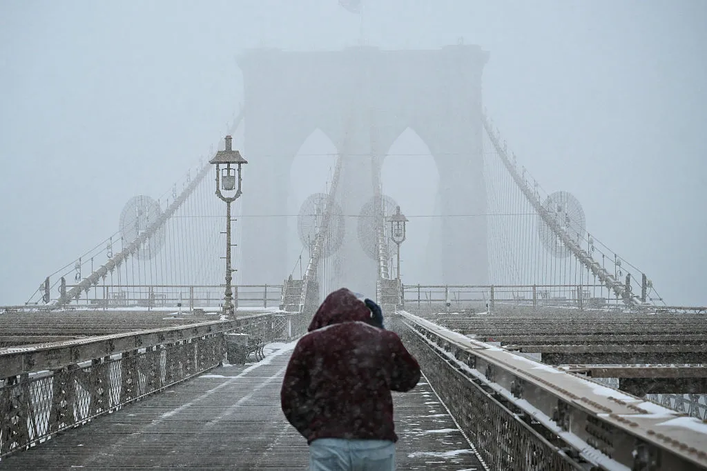 A man walks along the Brooklyn Bridge as snow falls in New York City last month.