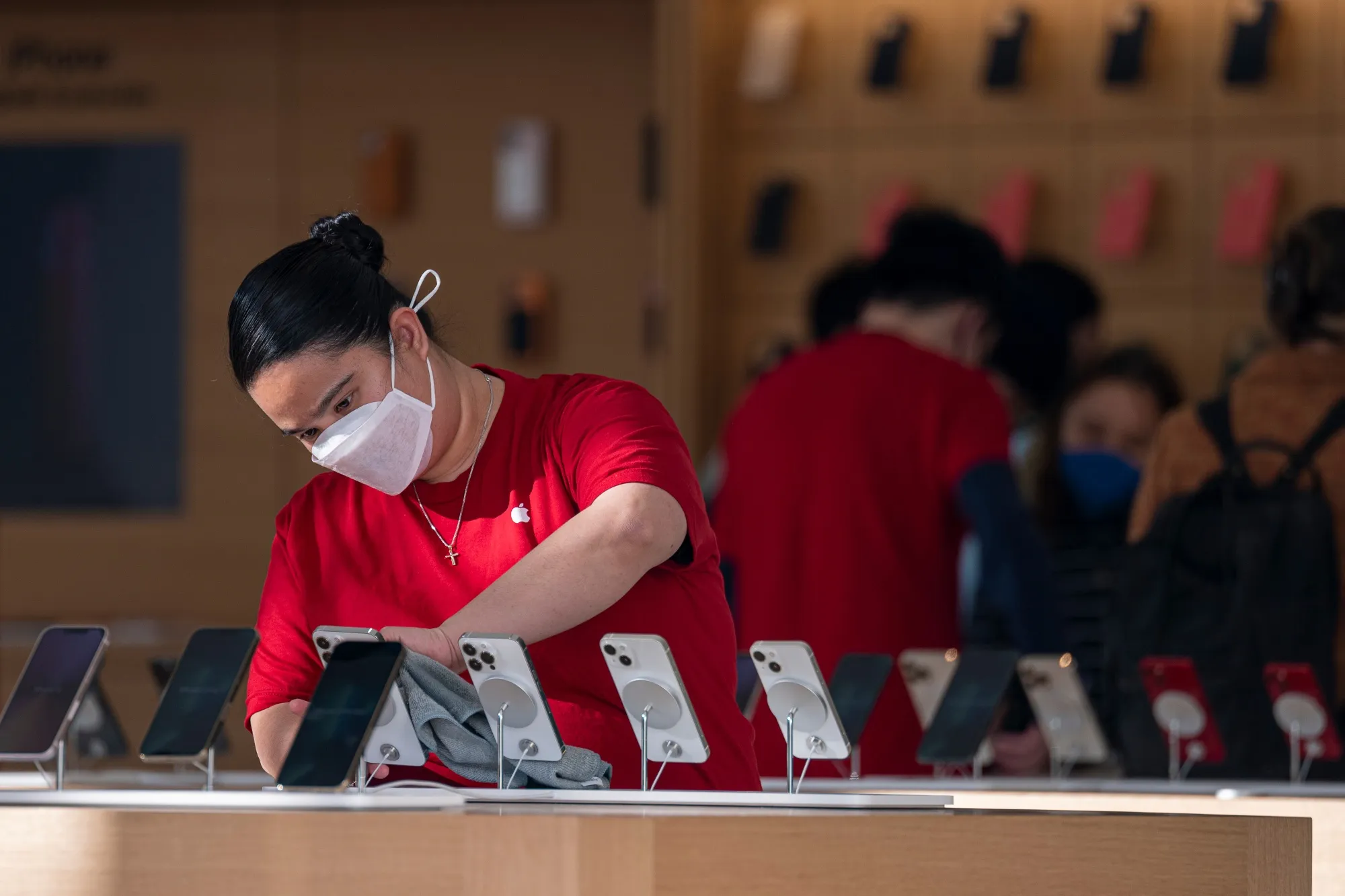 An employee cleans Apple iPhones at store in San Francisco, California.