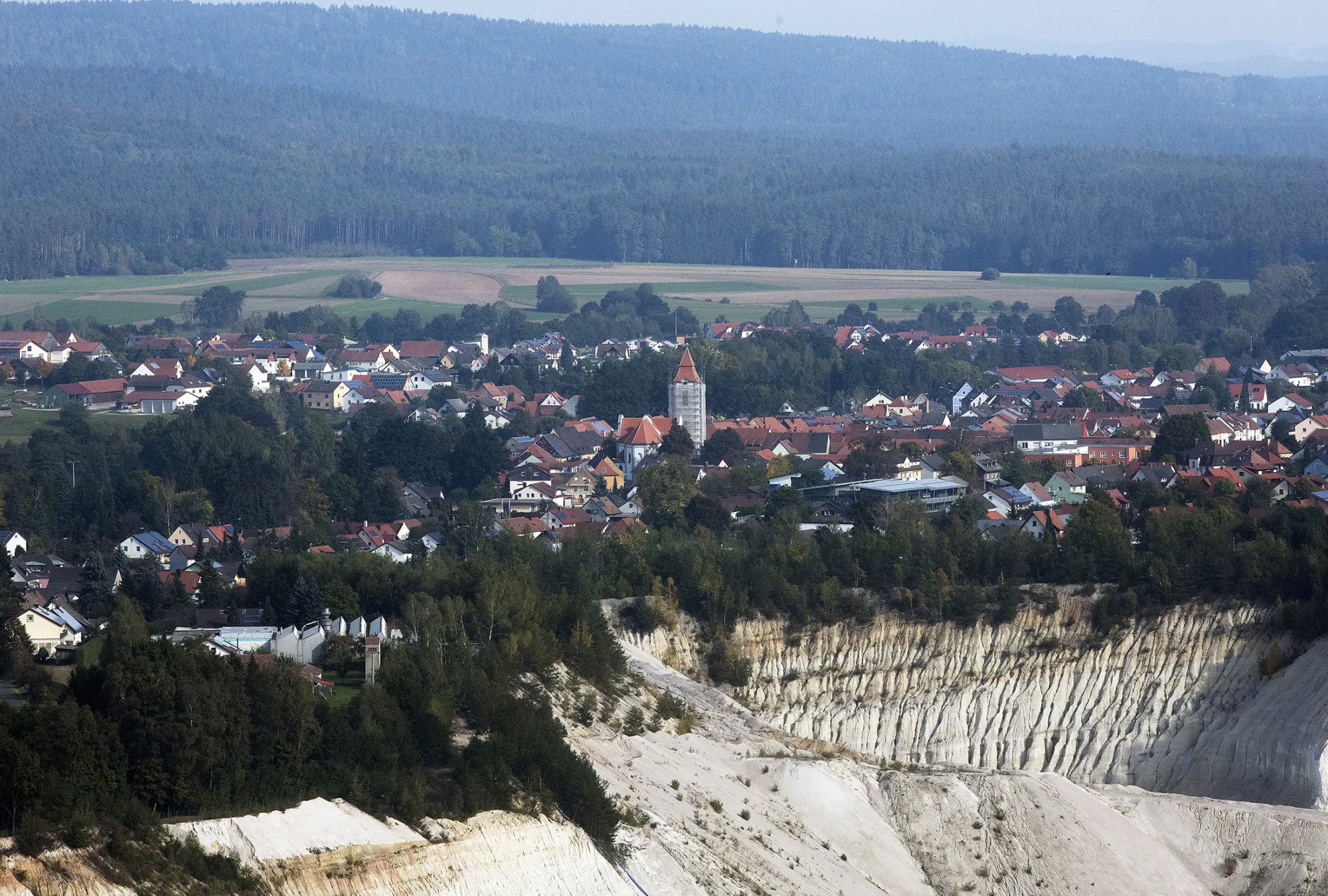 Trees and open fields surround the buildings and church in the Bavarian town of Schnaittenbach, Germany, on Friday, Oct. 14, 2016. MST a family-run shipping company, tucked away in the lush green hills of eastern Bavaria, is helping to bring new life to German shipping funds.
