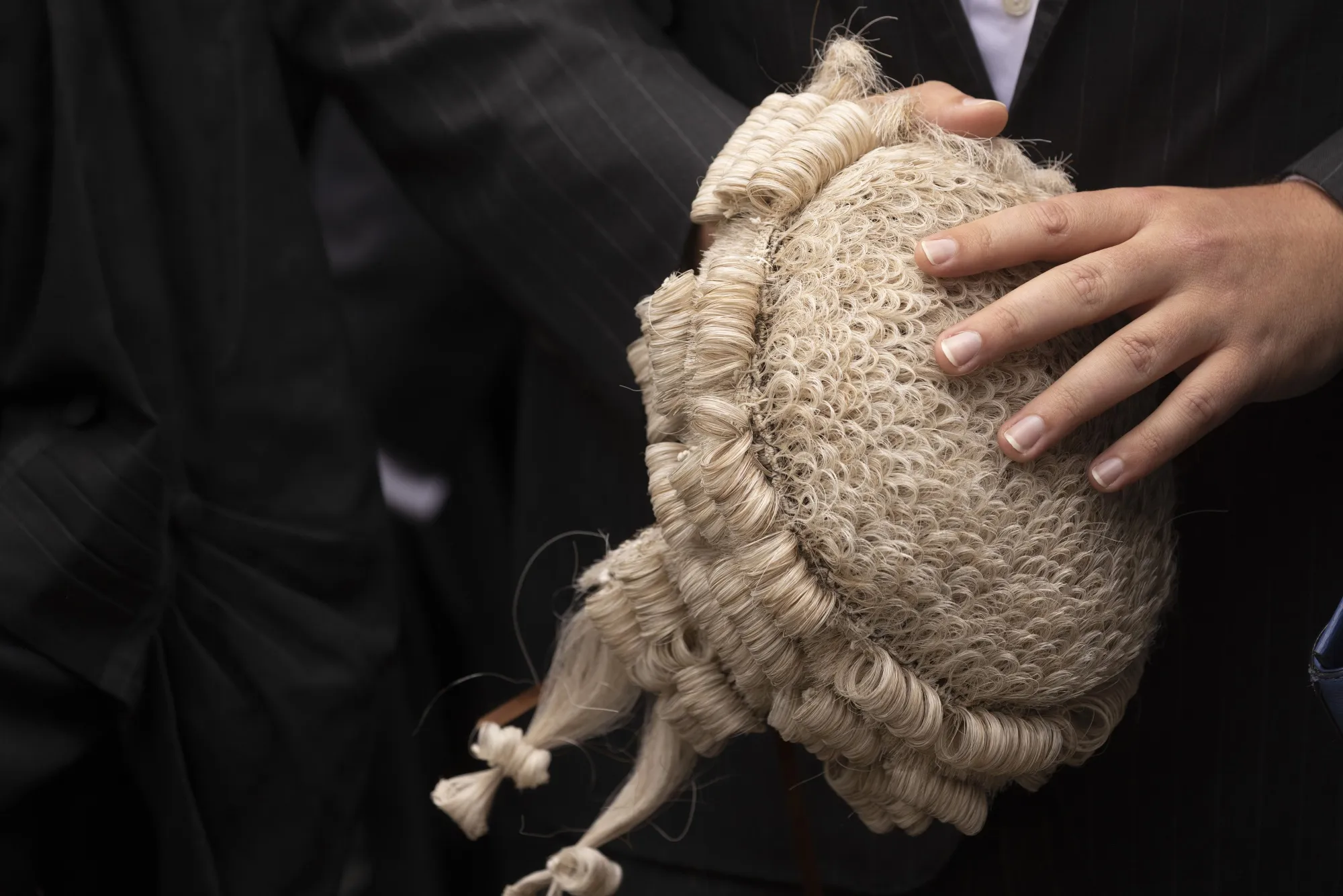 A barrister&nbsp;holds their&nbsp;horsehair wig during a protest outside the Old Bailey law courts in&nbsp;London, on June 27, 2022.